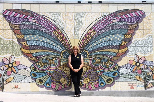 Jane Cage poses at the dedication of the new butterfly mural at Mercy Park in Joplin, MO. Anyone can become a butterfly - a symbol that has such meaning for Joplin, 2016